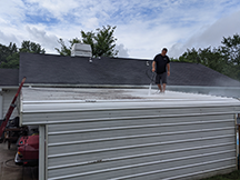 Shawn power washing roof of carport